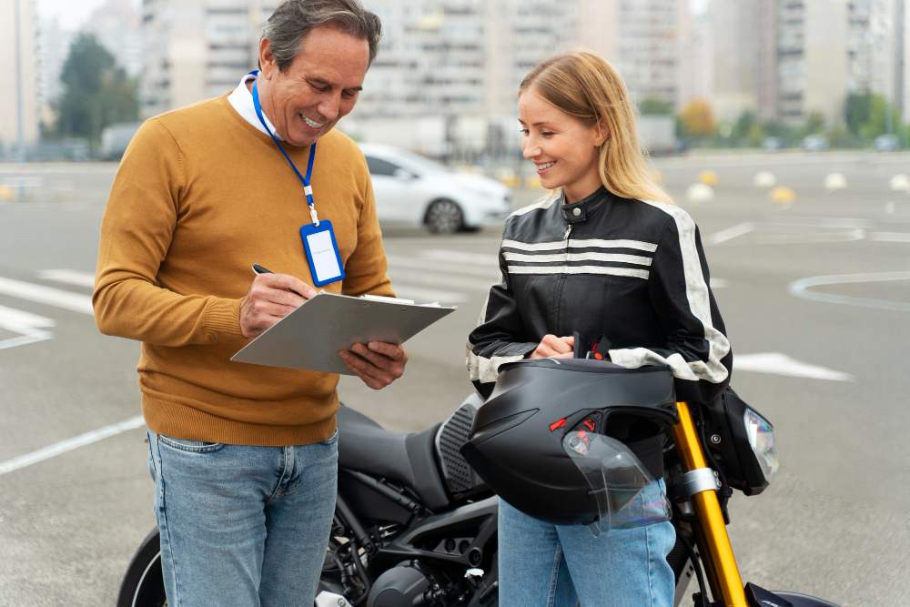 Persona firmando documentos con una mujer frente a una moto, representando el proceso de cómo hacer una transferencia de moto.